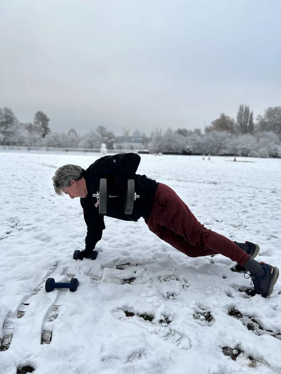 Client in his 50s training outdoors in Battersea Park in winter conditions
