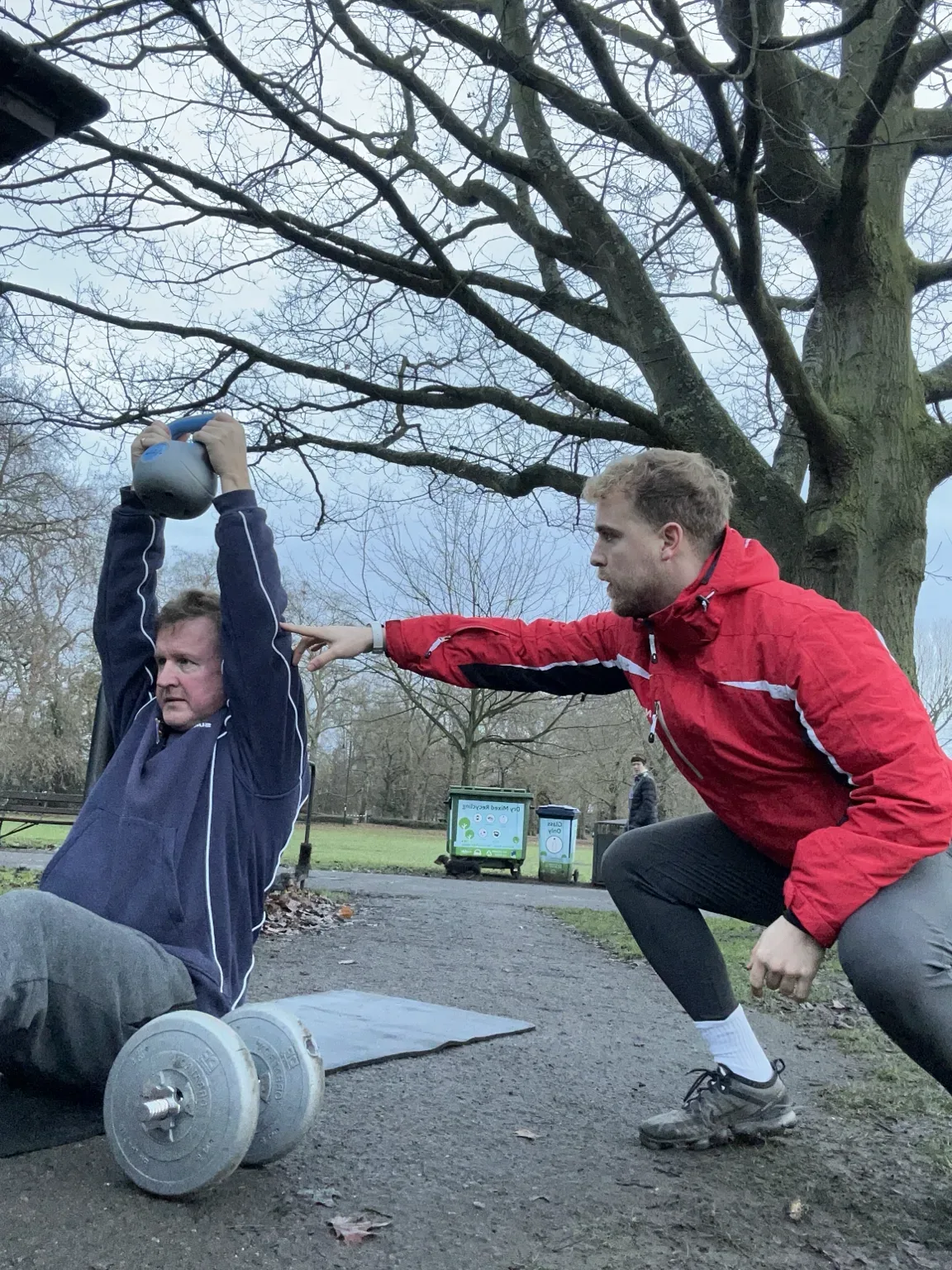 Dan Edwards coaching a client through rehabilitation exercises in Battersea Park